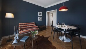 A modern living room with a sofa, a dining table with chairs, a red pendant light, and a floor lamp. - Cheese&Wine™ | Sra. do Monte - Viewpoint 1 (Guest Favorite) (Lisboa)