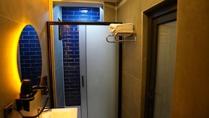 A bathroom with a sink, towel rack, and a door leading to a shower area. - Atlas Suit Otel (mersin)
