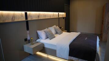 Un dormitorio moderno con cama, mesitas de noche y una lámpara de pared.