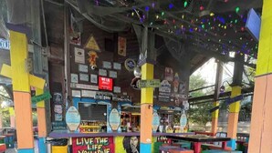 Um deck de madeira com assentos coloridos e uma placa que diz 'LIVE THE LIFE YOU LOVE'.