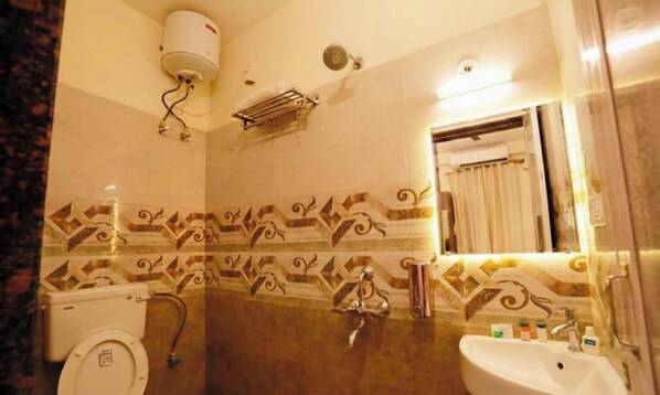Un baño con inodoro, lavamanos y cabina de ducha.