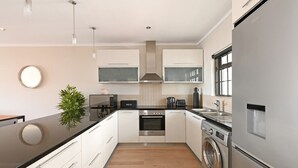 Una cocina moderna con una isla central, horno empotrado, microondas y lavavajillas.