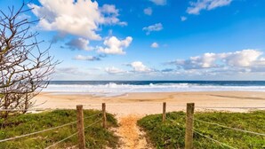 A beach path leading to the ocean with a wooden fence and greenery on either side. - Casa c Churrasqueira a 400m da Praia de Barra Nova (Saquarema)