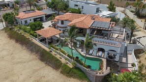 Ein mehrstöckiges Gebäude mit Pool, Solaranlage und Strandlage.