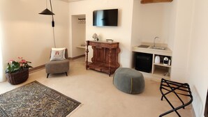A living room with a sofa, ottoman, and a television mounted on the wall. - Villa Arborea  (Trepuzzi)
