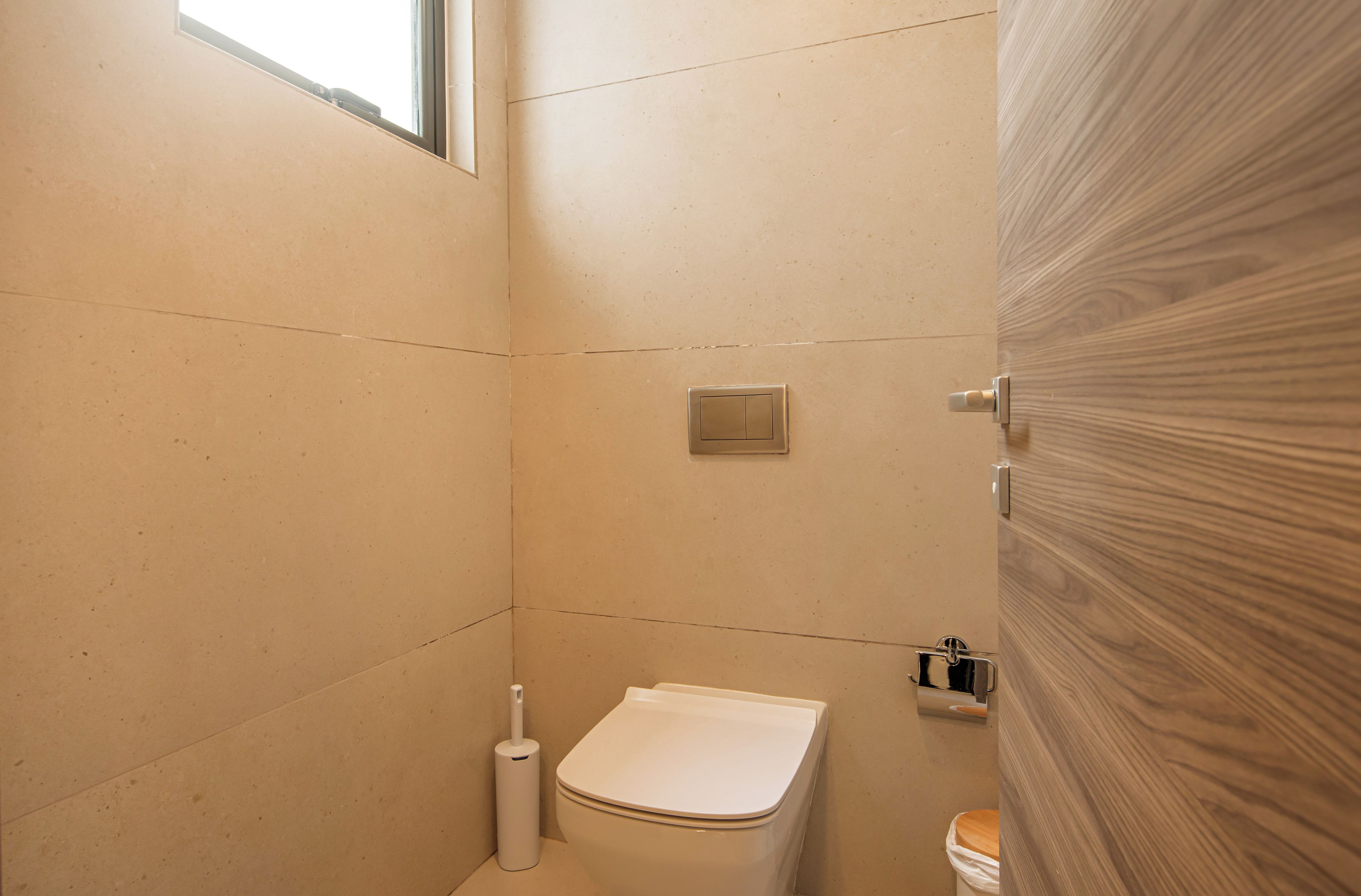 A small, modern bathroom with a toilet, a bidet, and a toilet paper holder.