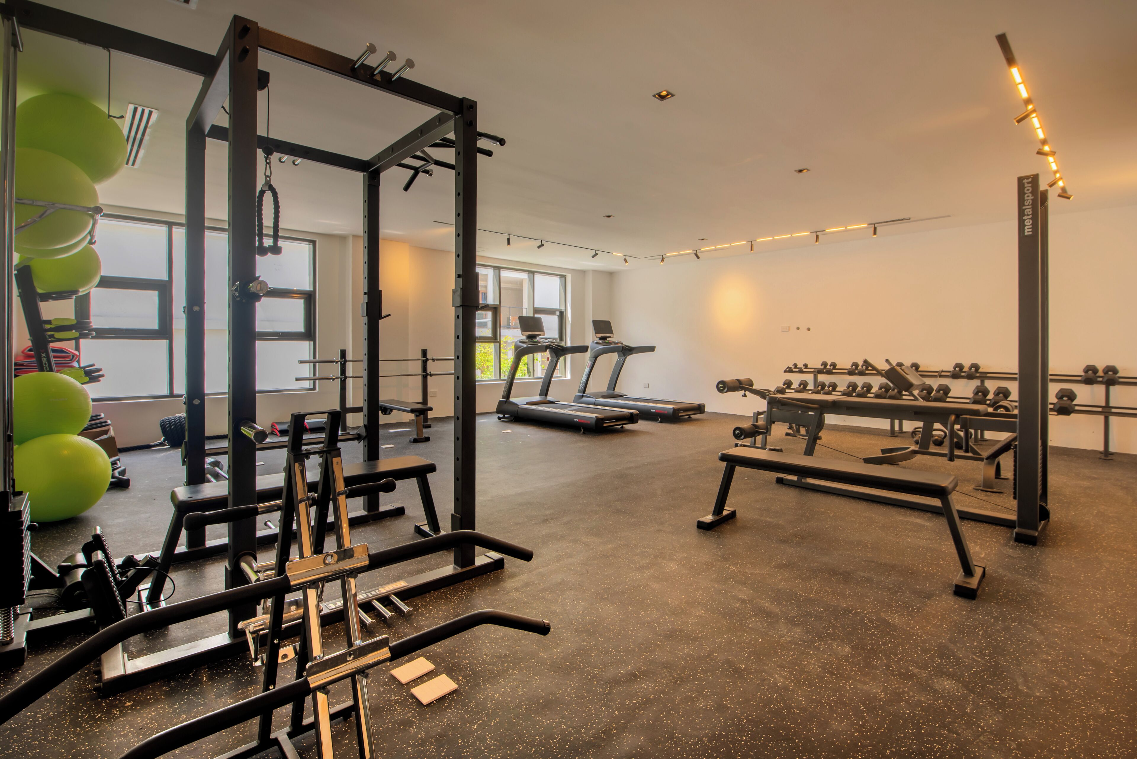 A gym with exercise equipment, treadmills, and weightlifting stations.