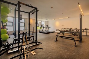 A gym with exercise equipment, treadmills, and weightlifting stations. - Nivia Punta Cana Hotel & Residences (Punta Cana)