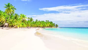 On the beach, white sand, sun loungers, beach umbrellas