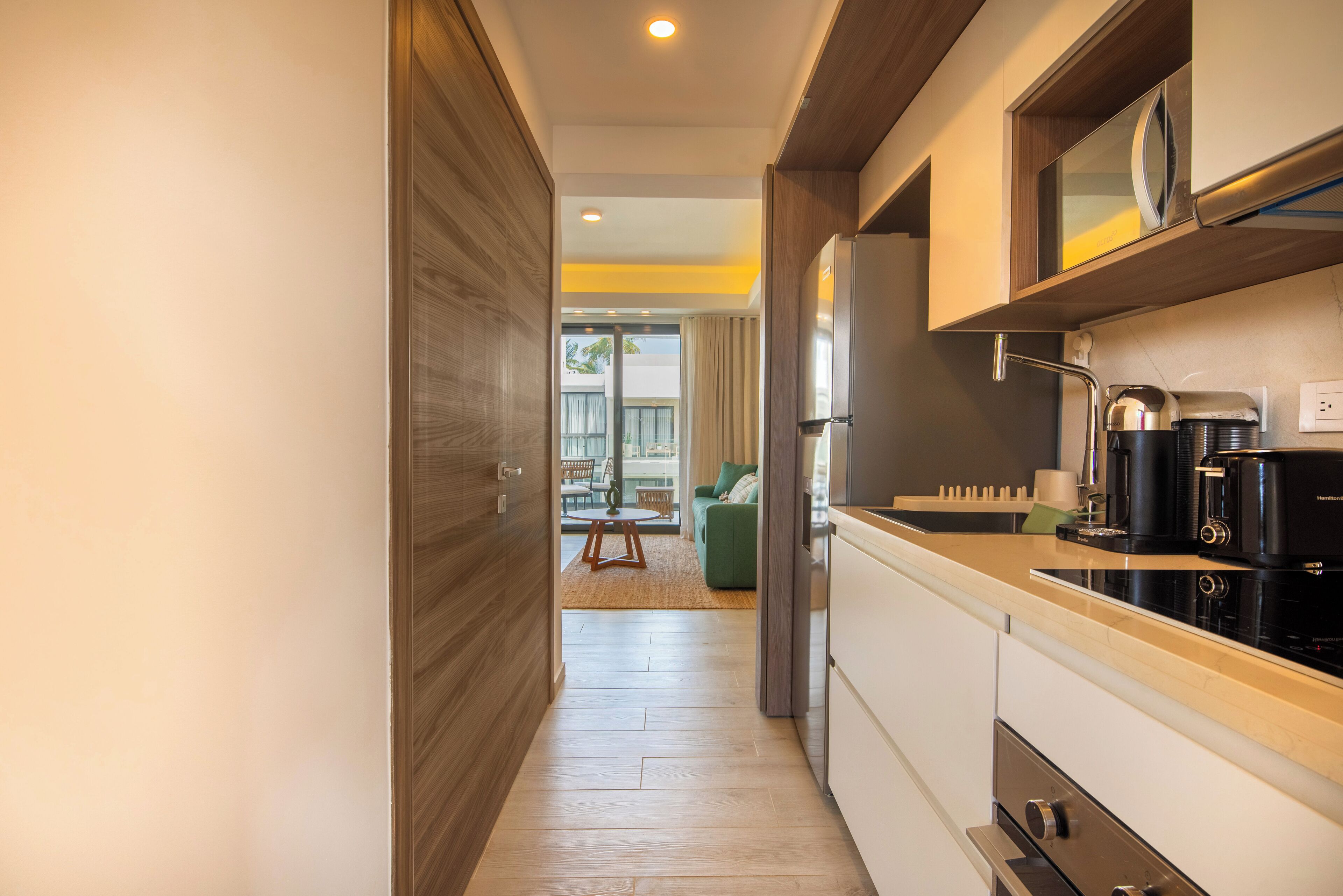 A modern kitchen with a built-in oven, a coffee maker, and a microwave.