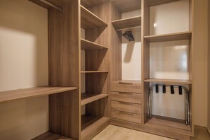 A walk-in closet with multiple wooden shelves and drawers. - Nivia Punta Cana Hotel & Residences (Punta Cana)