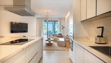 A modern kitchen with a central island, built-in appliances, and a dining area with a sofa and coffee table.