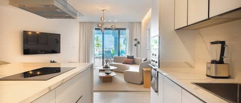 A modern kitchen with a central island, built-in appliances, and a dining area with a sofa and coffee table.
