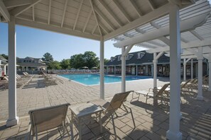 A covered outdoor pool area with lounge chairs and a clear view of the pool. - BLOCK WM Kingsgate 2br (Williamsburg)