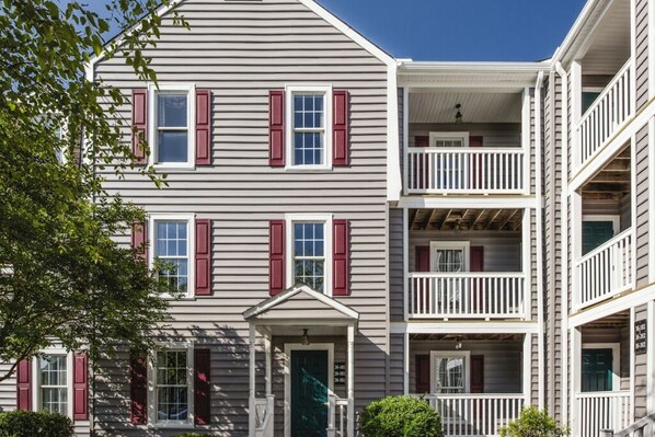 A multi-story building with a central entrance, balconies, and a porch. - BLOCK WM Kingsgate 2br (Williamsburg)
