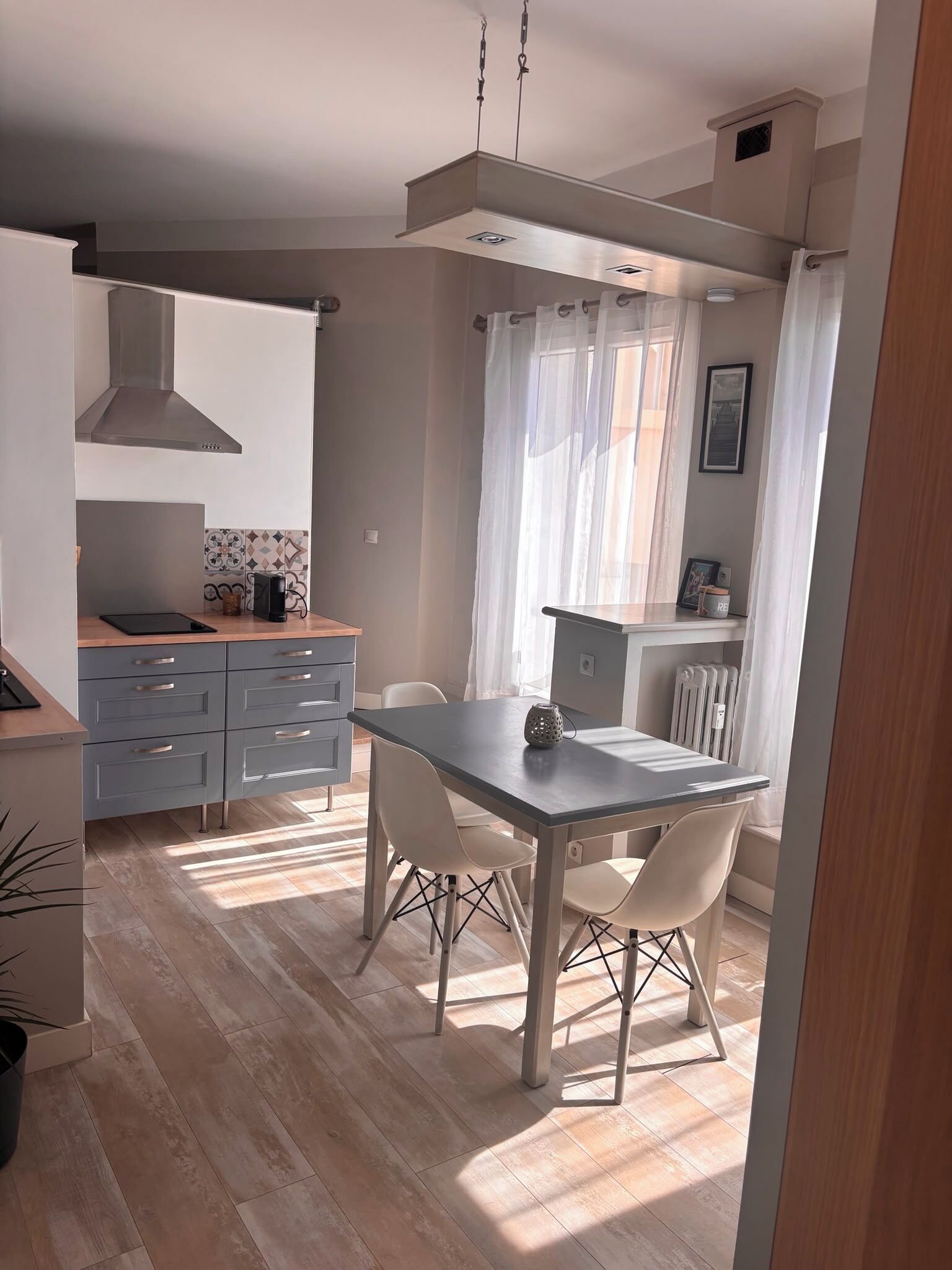 Una cucina moderna con zona pranzo, che include un tavolo, sedie e forno integrato.