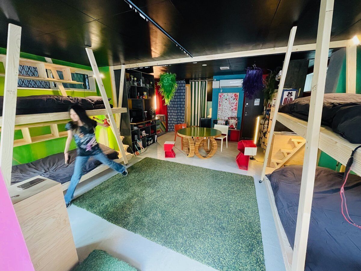 A room with bunk beds, a play area, and a table with chairs.