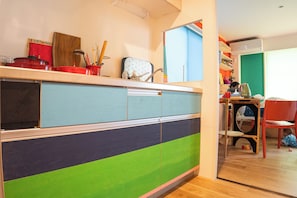 Una cocina con un mueble de colores, un lavamanos y un espejo.