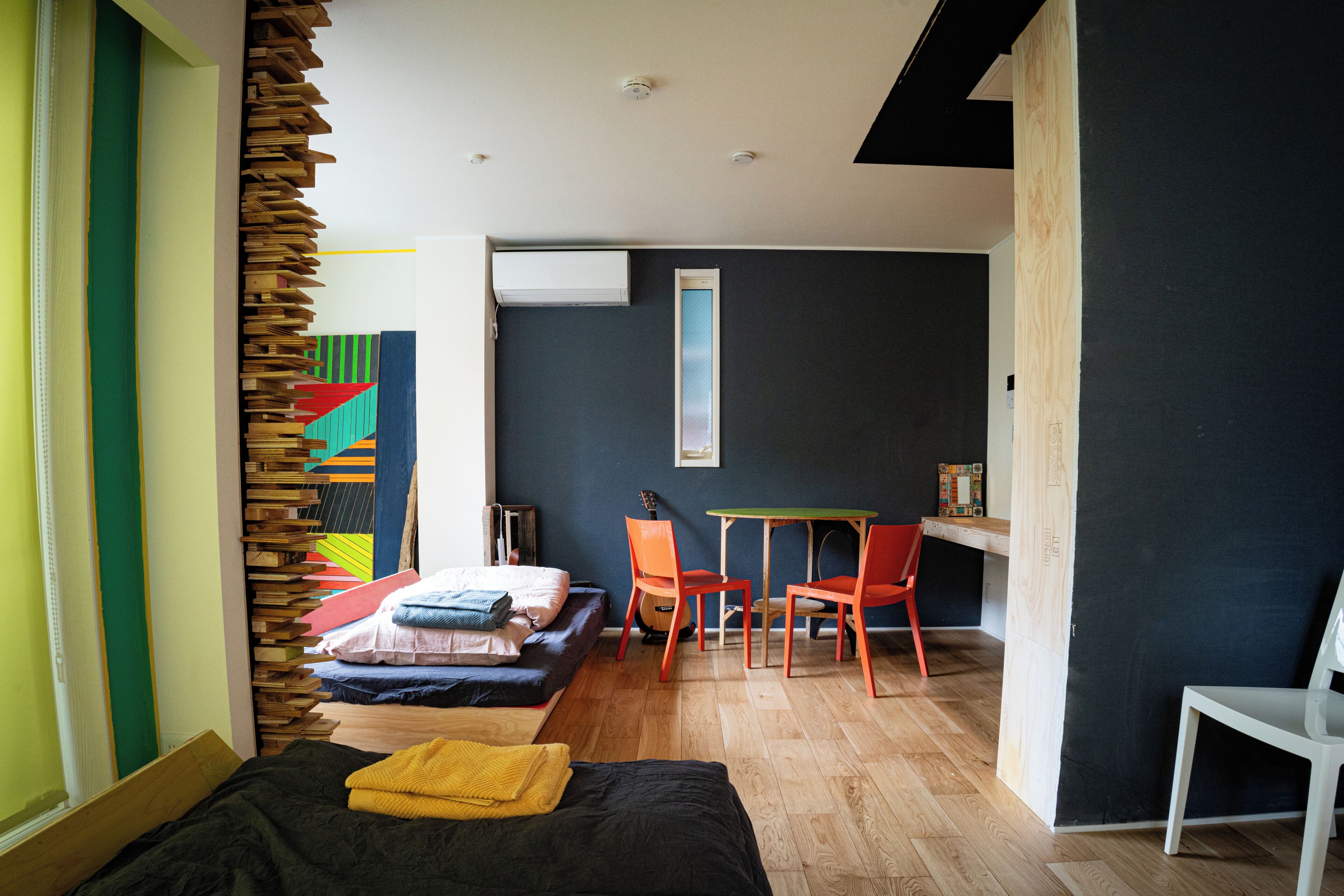 A modern bedroom with a bed, a desk, and two chairs.