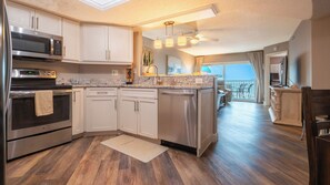 A modern kitchen with stainless steel appliances, a dishwasher, and a countertop with a sink. - Treat Yourself to Breathtaking Beachfront Views in this Sunlit and Spacious Corner Gem! (Indian Shores)