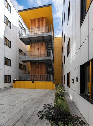 A multi-story building with a central atrium, balconies, and a staircase. - Student Only The Arch (Liverpool)