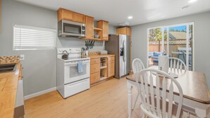 Una cocina con gabinetes de madera, un refrigerador de acero inoxidable, un microondas y una estufa.