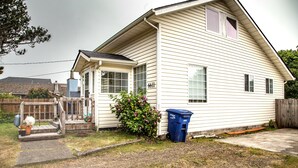 Une maison de plain-pied avec un porche à l’avant, un numéro bien visible, le « 6611 », et une poubelle bleue.