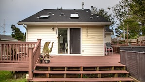 Une maison de plain-pied avec une terrasse à l’avant, une porte-fenêtre coulissante et une cheminée.