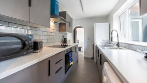 Une cuisine moderne équipée d’un four à micro-ondes, d’un four, d’un évier et d’une fenêtre.