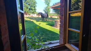 Blick durch eine Glastür in einen Raum mit Backsteinwand und Holzboden.