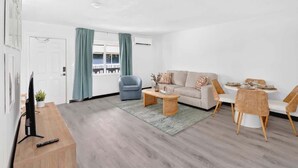Ein modernes Wohnzimmer mit einer Couch, einem Couchtisch und einem Esstisch.