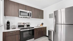 Una cocina moderna con alacenas de madera oscura, electrodomésticos de acero inoxidable y un horno empotrado.