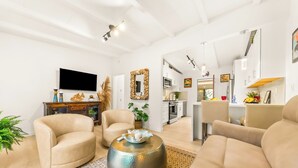 A modern living room with a sofa, armchairs, a coffee table, and a flat-screen TV. - Walk To Beach and Village W/Jacuzzi & Firepit W/Great Reviews! (San Diego)