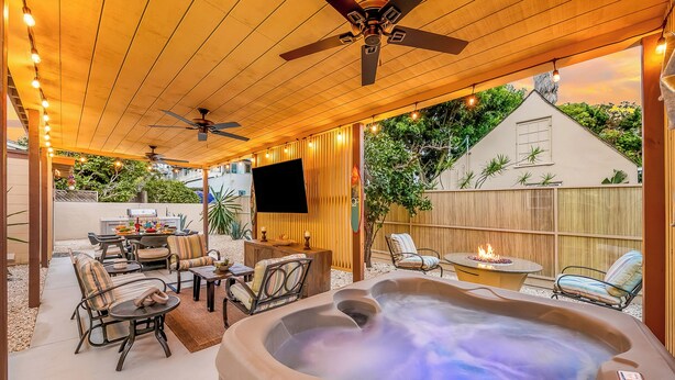 A covered patio with a hot tub, seating area, and a TV screen. - Walk To Beach and Village W/Jacuzzi & Firepit W/Great Reviews! (San Diego)