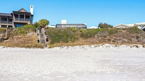 A beachfront property with a modern house, a covered walkway, and a sandy beach. - 5BR Gulf-Front Home with Private Beach & Heated Pool ~ Sleeps 12 (Seacrest)
