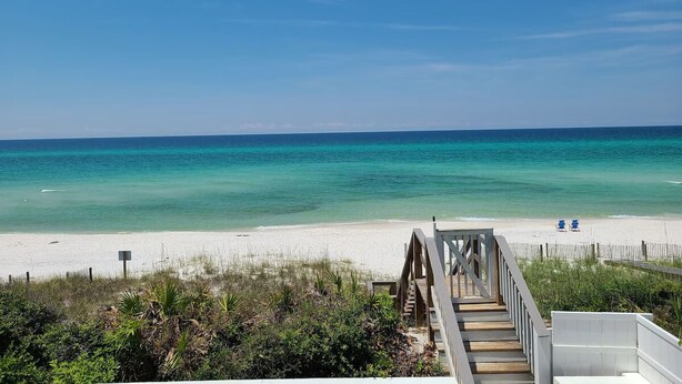 A beach with a wooden walkway leading to the shore, a white sandy beach, and a clear blue ocean. - 5BR Gulf-Front Home with Private Beach & Heated Pool ~ Sleeps 12 (Seacrest)