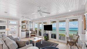 A spacious living room with a television, seating area, and a view of the ocean. - 5BR Gulf-Front Home with Private Beach & Heated Pool ~ Sleeps 12 (Seacrest)