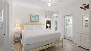 A bedroom with a bed, bedside table, lamp, ceiling fan, and a door with a view. - 5BR Gulf-Front Home with Private Beach & Heated Pool ~ Sleeps 12 (Seacrest)