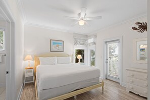A bedroom with a bed, bedside table, lamp, ceiling fan, and a door with a view. - 5BR Gulf-Front Home with Private Beach & Heated Pool ~ Sleeps 12 (Seacrest)