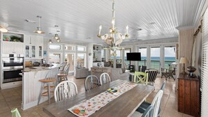 A spacious kitchen with modern appliances, a dining area with a wooden table, and a view of the ocean. - 5BR Gulf-Front Home with Private Beach & Heated Pool ~ Sleeps 12 (Seacrest)