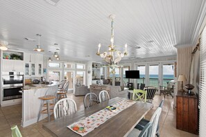 A spacious kitchen with modern appliances, a dining area with a wooden table, and a view of the ocean. - 5BR Gulf-Front Home with Private Beach & Heated Pool ~ Sleeps 12 (Seacrest)