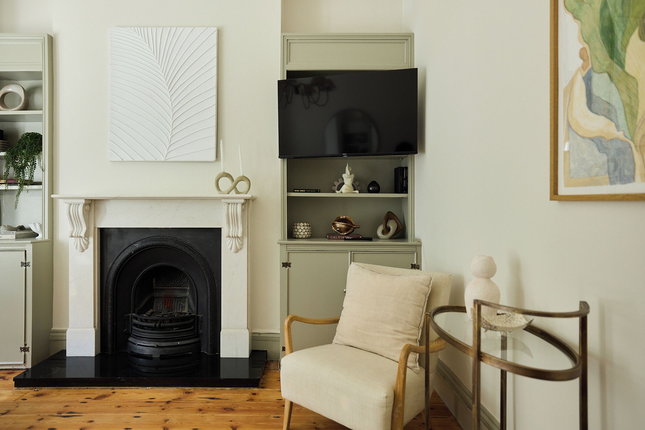 Una sala de estar con chimenea, televisor y estantería.