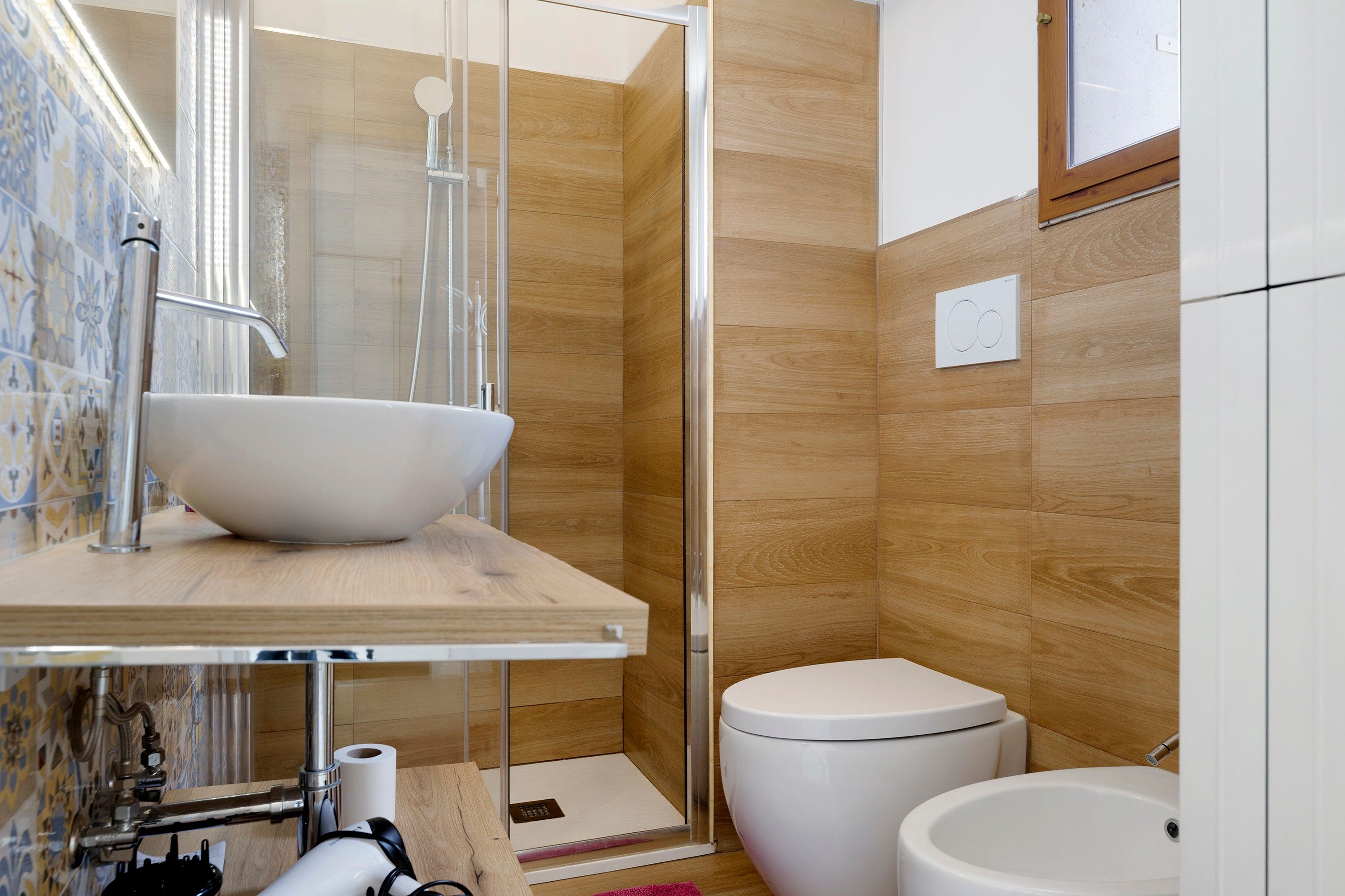 Une salle de bain moderne avec un grand lavabo blanc, des toilettes et un espace douche.
