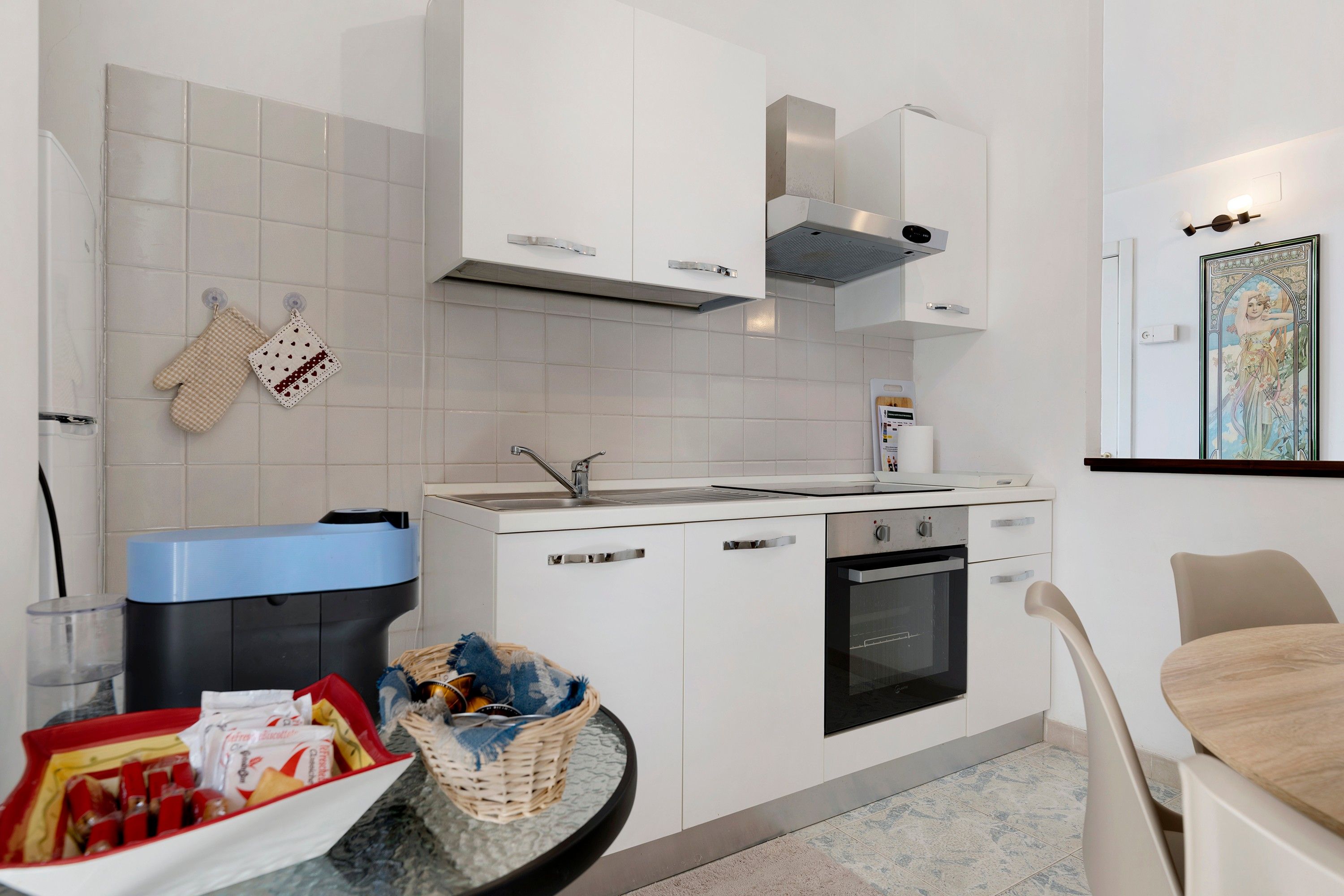 A modern kitchen with white cabinets, a built-in oven, and a microwave.