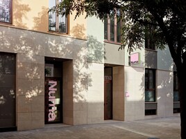 Fachada de edificio con escaparate que dice 'Numa' y una puerta con el mismo nombre.