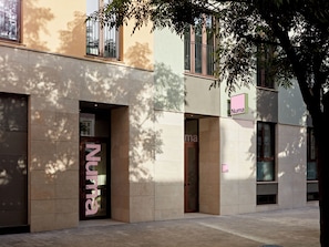 Fachada de edificio con escaparate que dice 'Numa' y una puerta con el mismo nombre.