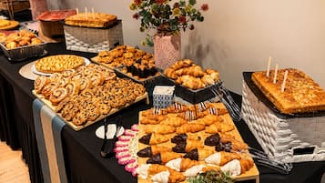 A buffet table with various baked goods and pastries.