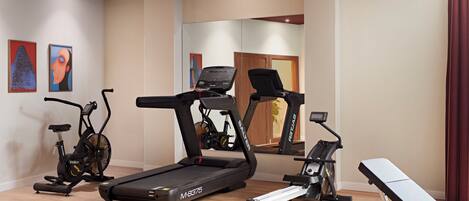 A home gym with treadmills, an elliptical, and a rowing machine.