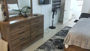 A bedroom with a bed, a dresser, a TV, and a fan. - DraxHall Villa (Saint Ann's Bay)