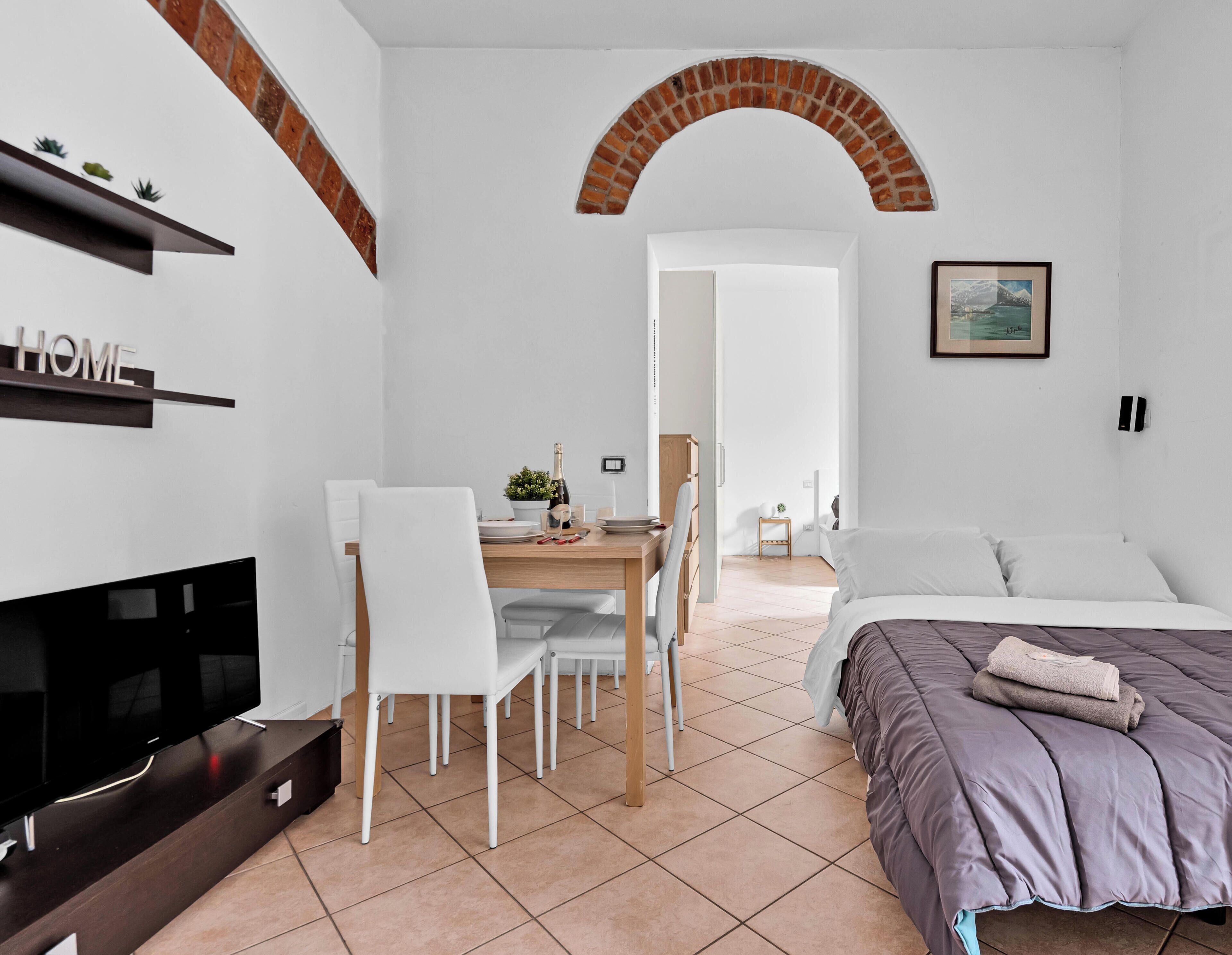 Une chambre à coucher moderne avec un lit, un bureau et un téléviseur.